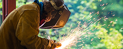 Student welding with sparks flying