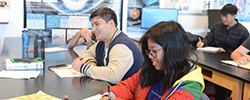 Three students sitting in a classroom