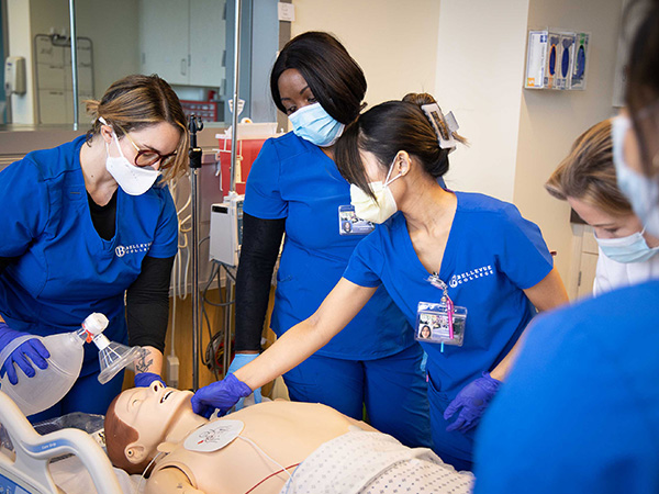 Nursing students practicing CPR on a mannequin